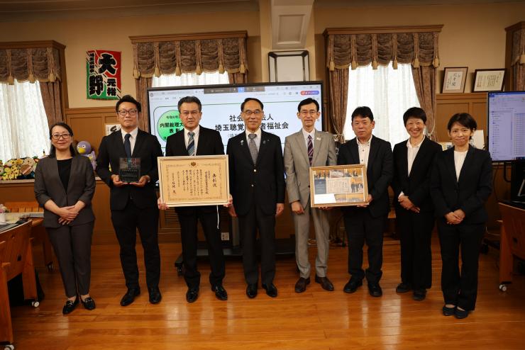 表敬訪問で訪問者と記念写真を撮る知事の写真