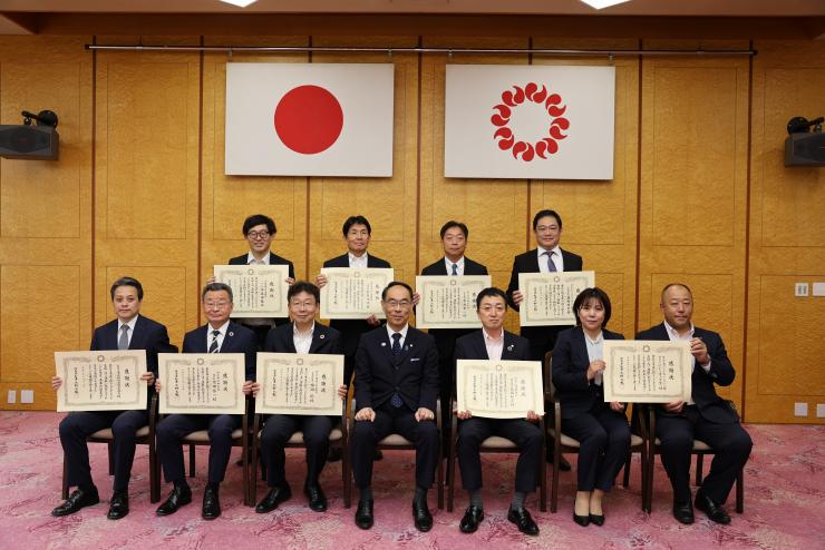 感謝状贈呈式で表彰者と記念写真を撮る知事の写真
