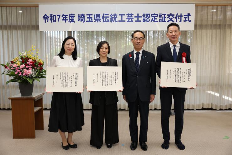 交付式で表彰者と記念写真を撮る知事の写真