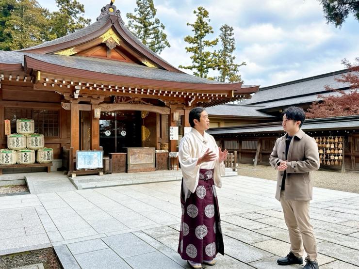 日高市の高麗神社で話す宮司と小堺翔太リポーター