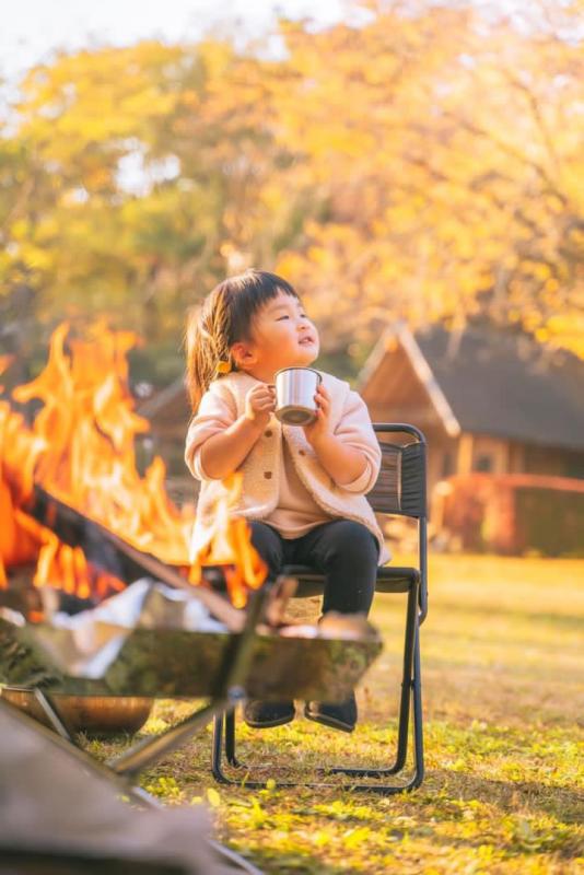 最優秀賞の写真：たき火の前で椅子に座りお茶を楽しむ子供