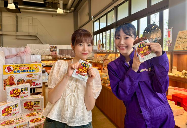 三州製菓のエステラスでせんべいを食べる島崎遥香さんと松井咲子さんの写真