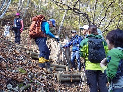 レクチャーを受けながら、登山道の木製の階段を登っている様子。