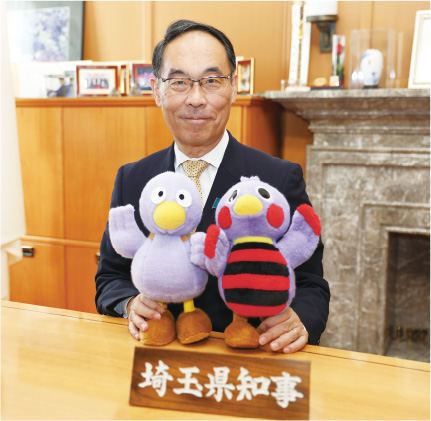 埼玉県知事 大野元裕 写真：埼玉県マスコット「コバトン」「さいたまっち」のぬいぐるみを持って撮影