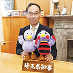 埼玉県知事 大野元裕 写真：埼玉県マスコット「コバトン」「さいたまっち」のぬいぐるみを持って撮影