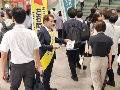 駅利用者にチラシを配布する副議長の写真