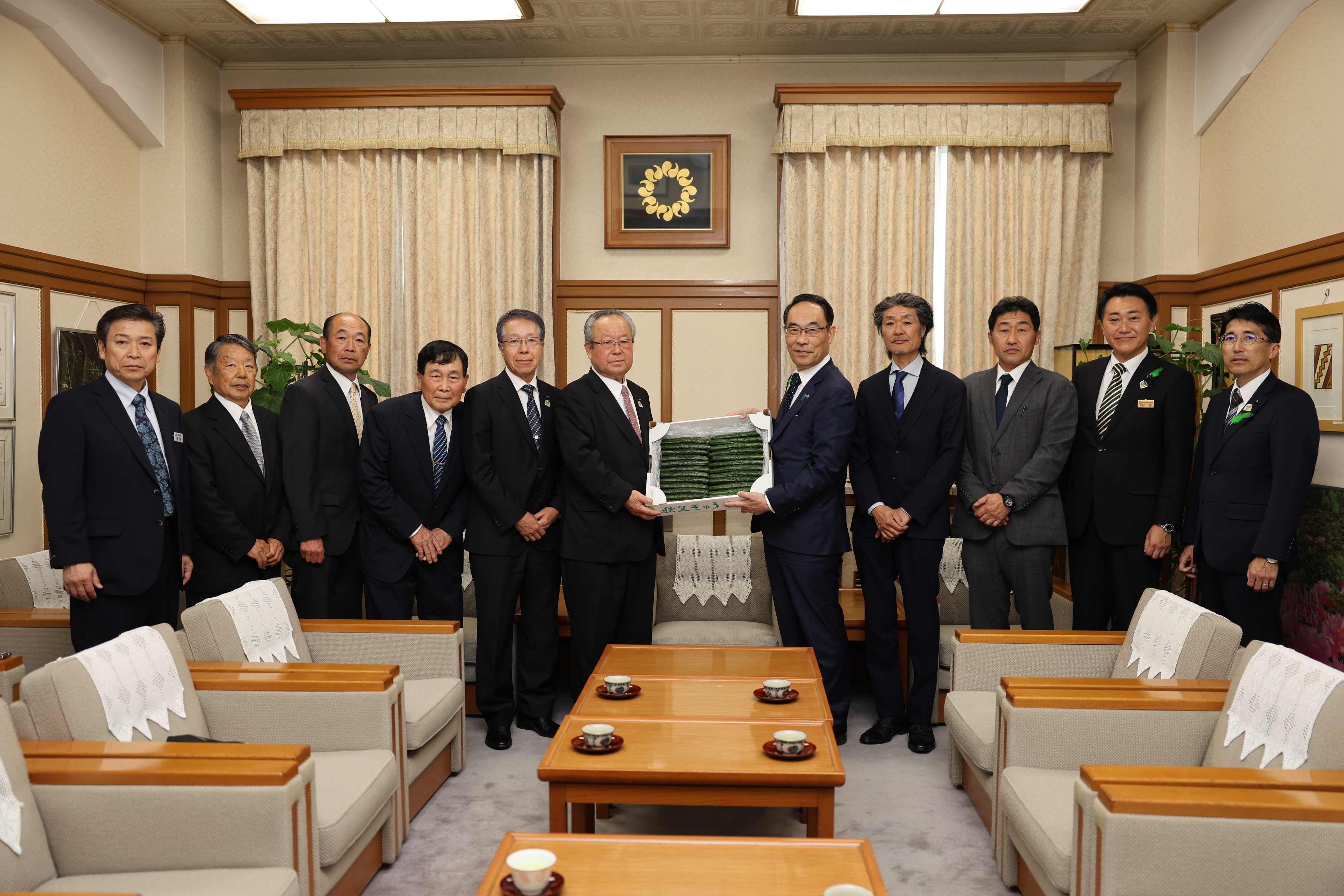 表敬訪問で訪問者と集合写真を撮る知事の写真