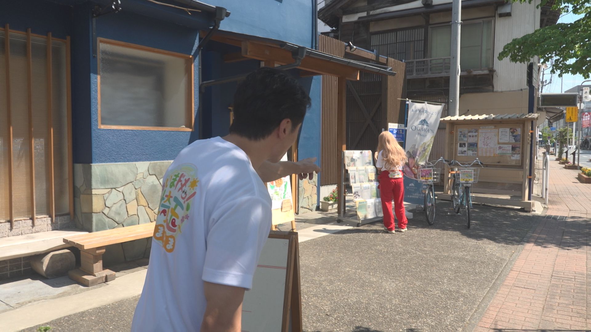 岡本寛志がかつらを被ったアンゴラ村長に歩み寄るシーン
