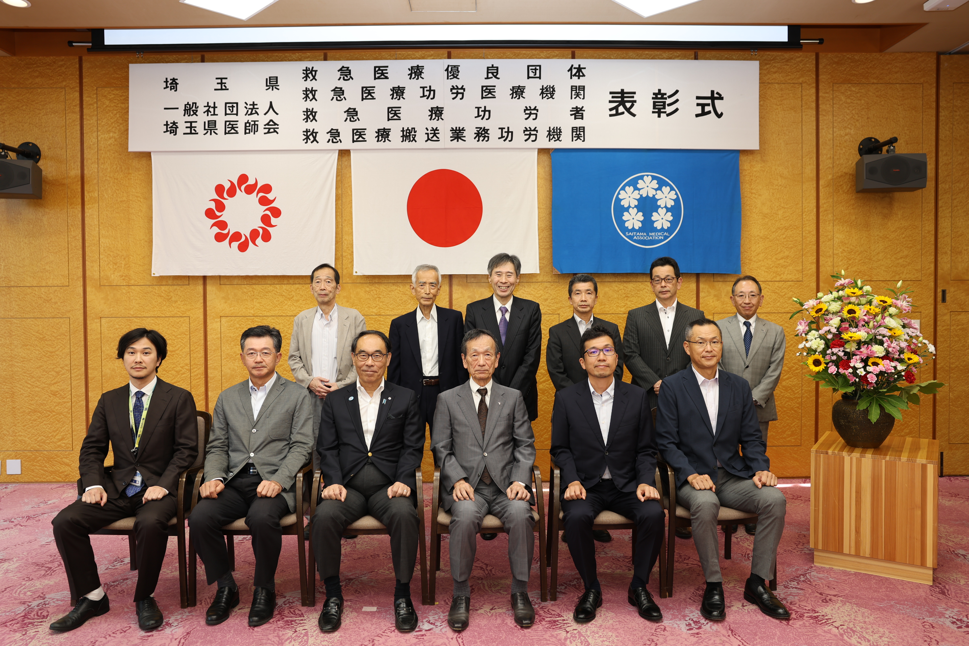 表彰式で表彰者と集合写真を撮る知事の写真