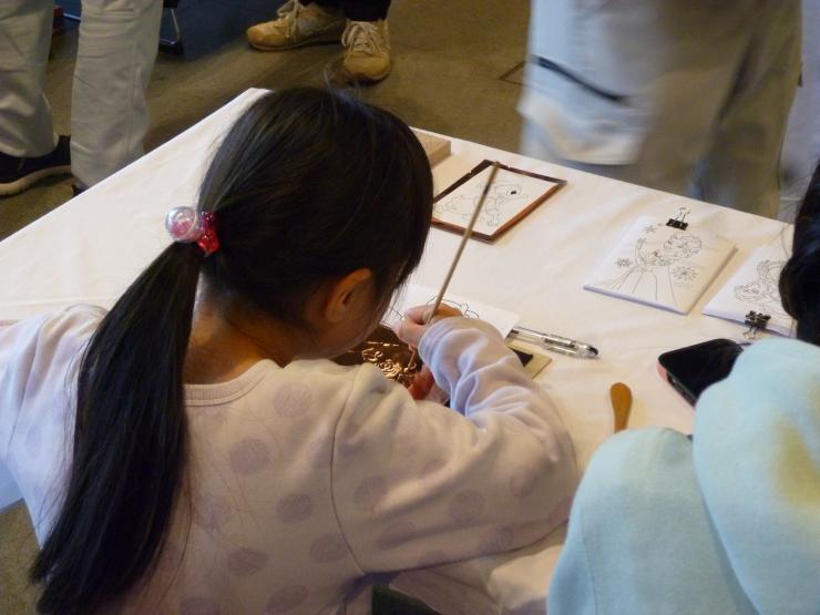 銅板でレリーフを作るこどもの写真