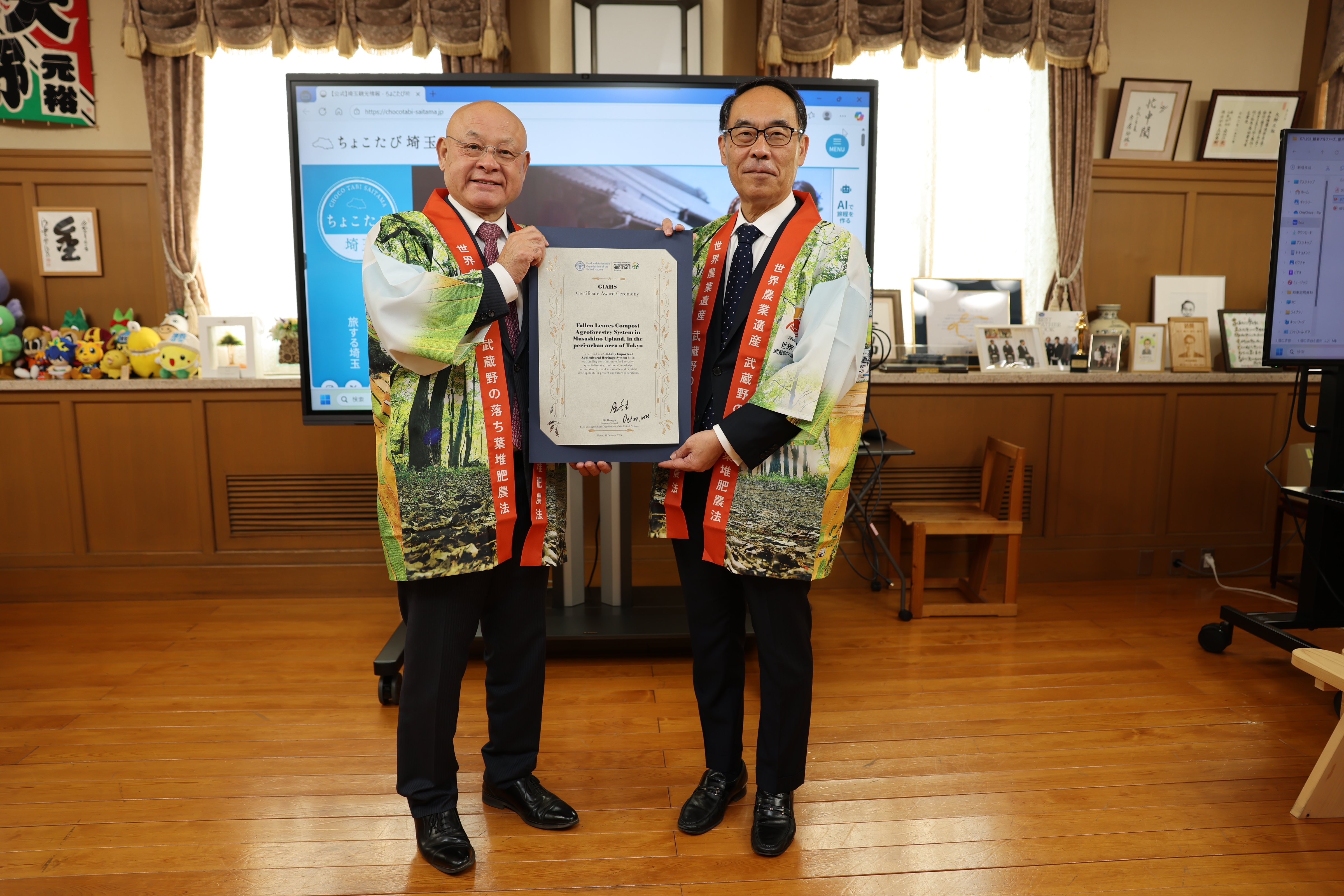 訪問者と認定証とともに記念撮影する知事の写真