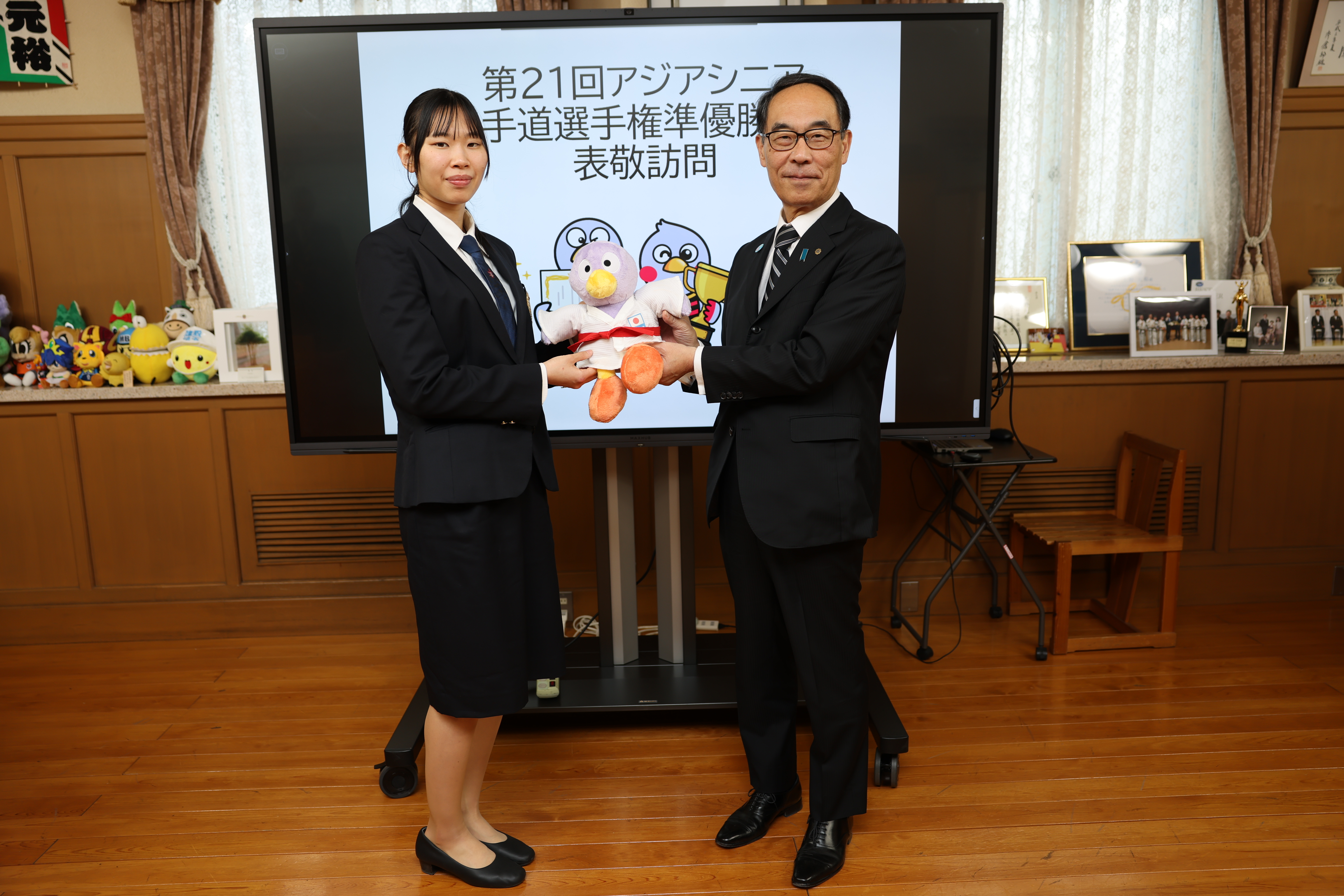 訪問者と記念写真を撮る知事の写真